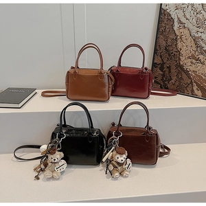 Sacs Boston rétro en cuir marron, bordeaux et noir avec des breloques oursons