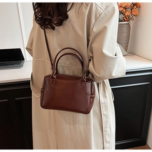 Braune Leder-Umhängetasche kombiniert mit einem beigen Trenchcoat im modernen Büro-Stil