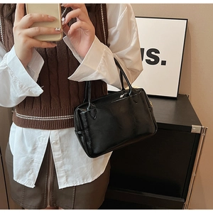 Detailansicht der schwarzen Lackleder-Handtasche mit Doppelgriffen und Reißverschluss
