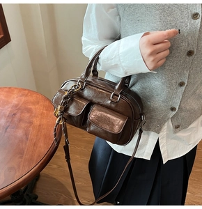 Detail view of a vintage brown oil-wax leather Boston bag with dual flap pockets