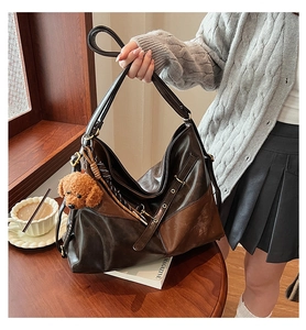 Détail du sac hobo en cuir patchwork marron avec un porte-clés en peluche chiot