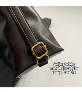 Gros plan sur la boucle dorée réglable du sac cabas en cuir marron foncé haut de gamme