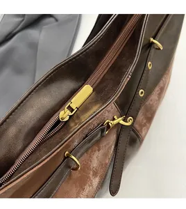 Gros plan sur la fermeture éclair en métal et le similicuir texturé du sac vintage