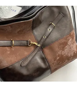 Détail de cuir marron foncé et de daim avec anneaux et crochets en métal doré