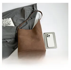 Brown bucket bag size comparison with tablet and phone showing large capacity