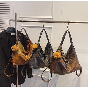 Vue détaillée de sacs cabas triangulaires en cuir huilé avec breloques d'ours en peluche