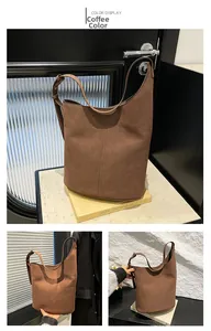 Detail view of coffee brown suede bucket bag featuring contrast stitching and adjustable strap