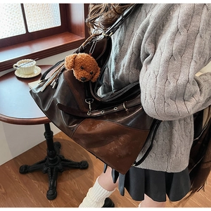 Détail du grand sac cabas marron foncé avec texture suédée et breloque ours en peluche
