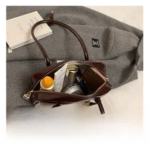 Detailed interior of the dark brown leather bowling bag showing daily essentials