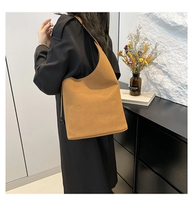 Detailed view of camel suede shoulder bag showing stitching and thick leather texture