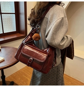 Détail du sac cabas bordeaux en similicuir avec poche à boucle et charm ourson