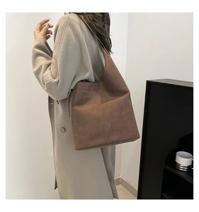 Side view of a large brown suede hobo bag with adjustable strap for daily commute