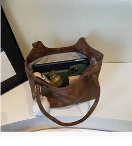 Top view of spacious interior of brown glossy leather tote bag with storage compartments