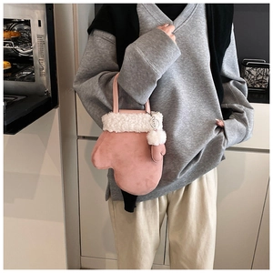 Pink mitten-shaped bucket bag with plush white faux fur trim in a cozy kitchen setting