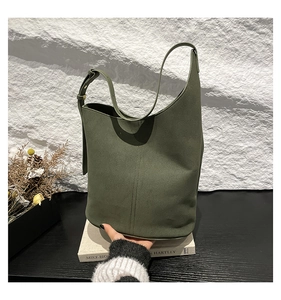 Detail of dark green matte shoulder bag with adjustable strap and suede texture