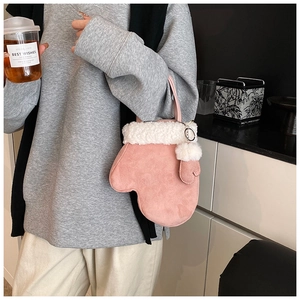 Detail of pink glove-shaped handbag with white faux fur trim and fluffy pompom accessory
