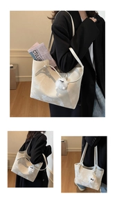 Detail of silver tote bag featuring marble texture and white plush pompom charm decoration