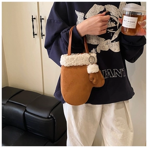 Close-up of brown suede glove-shaped handbag with plush white faux shearling trim details