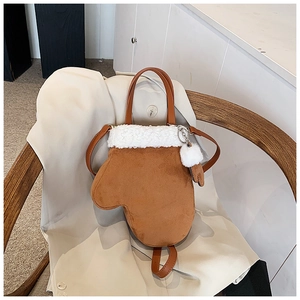 Detail der kreativen Umhängetasche in Handschuhform aus braunem Wildleder mit weißem Pelz