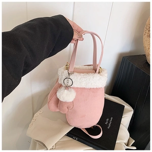 Pink bucket bag with white faux fur trim, heart charm, and plush ball detail