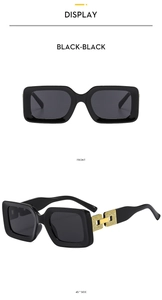 Detail of square black sunglasses featuring hollowed-out gold chain temple accents