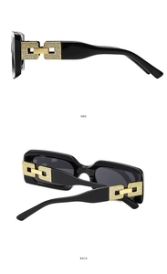 Detail view of square black sunglasses with gold hollowed metal temple design and accents