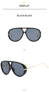Close-up of aviator sunglasses with black oversized frames and gold metal temples