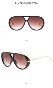 Detail view of oversized pilot sunglasses with gold metal temples and brown gradient lenses