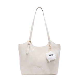 Fashionable beige tote bag with shoulder strap and plush charm on white background