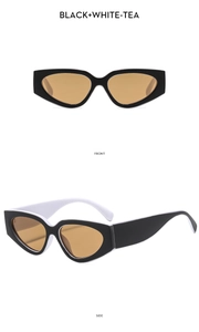 Detail view of cat eye sunglasses with black and white frames and tea-tinted lenses