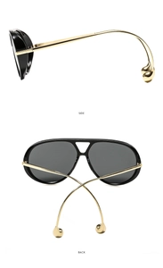 Detail of curved gold metal temples with round bead ends on large aviator sunglasses