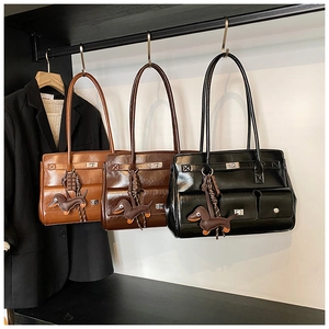 Close-up of three vintage leather tote bags in brown, coffee, and black with cute charms