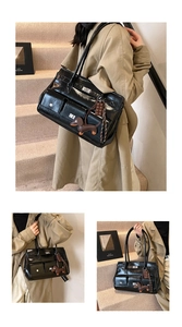 Detail of black glossy commuter tote with functional pockets and dachshund charm