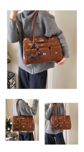 Detail view of brown vintage leather handbag with multiple pockets and dog charm