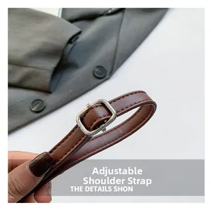 Detail of dark brown leather adjustable strap with silver metal buckle and neat stitching