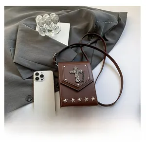 Macro shot of brown retro crossbody bag featuring silver metal cross and star studs