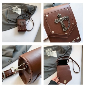 Macro detail of vintage brown crossbody bag with silver cross chain and star rivets