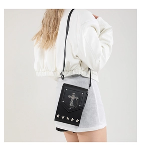 Detail of gothic black leather crossbody bag with silver cross and star rivets