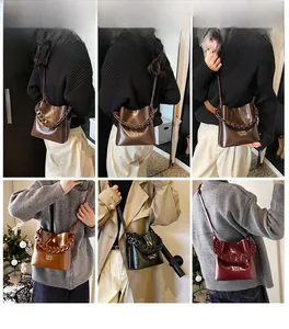 Détail du sac seau vintage en cuir ciré montrant la chaîne et l'inscription gaufrée