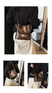 Détail du sac en cuir ciré marron foncé avec logo COIN 2DH doré et bandoulière chaîne