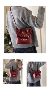 Sac seau rouge foncé en cuir ciré brillant avec grosse chaîne présenté sous divers angles
