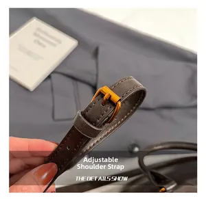Detail of adjustable dark brown litchi grain leather strap with gold metal buckle