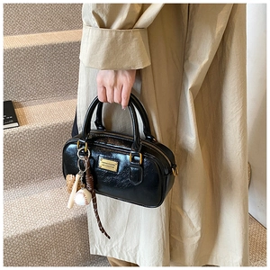 Stylish black patent Boston shoulder bag for women, casual commuter handbag with chic charms.