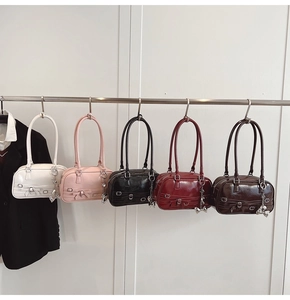 Détail de cinq sacs à main rétro en similicuir coloré avec nœuds et pendentifs en métal