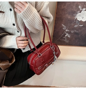 Sac Boston rouge foncé en cuir verni avec chaîne argentée et nœud sur le côté