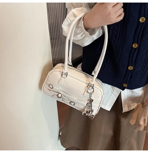 Détail du sac boston en cuir PU blanc avec boucle argentée et breloque ours