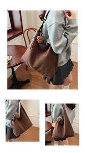 Detail of a brown suede tote bag featuring a plush bear charm and striped silk scarf wrap
