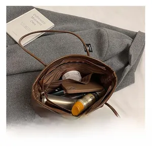 Interior view of brown tote bag showing large capacity with striped lining and zipper pocket