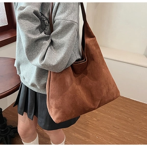 Macro shot of brown suede hobo tote bag showing soft matte texture and large capacity