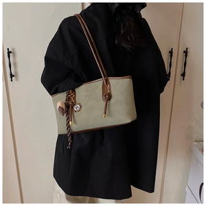Detail of Morandi green suede bag with brown leather trim and knotted handle decoration